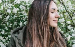 Young girl relaxing in front of a blooming tree